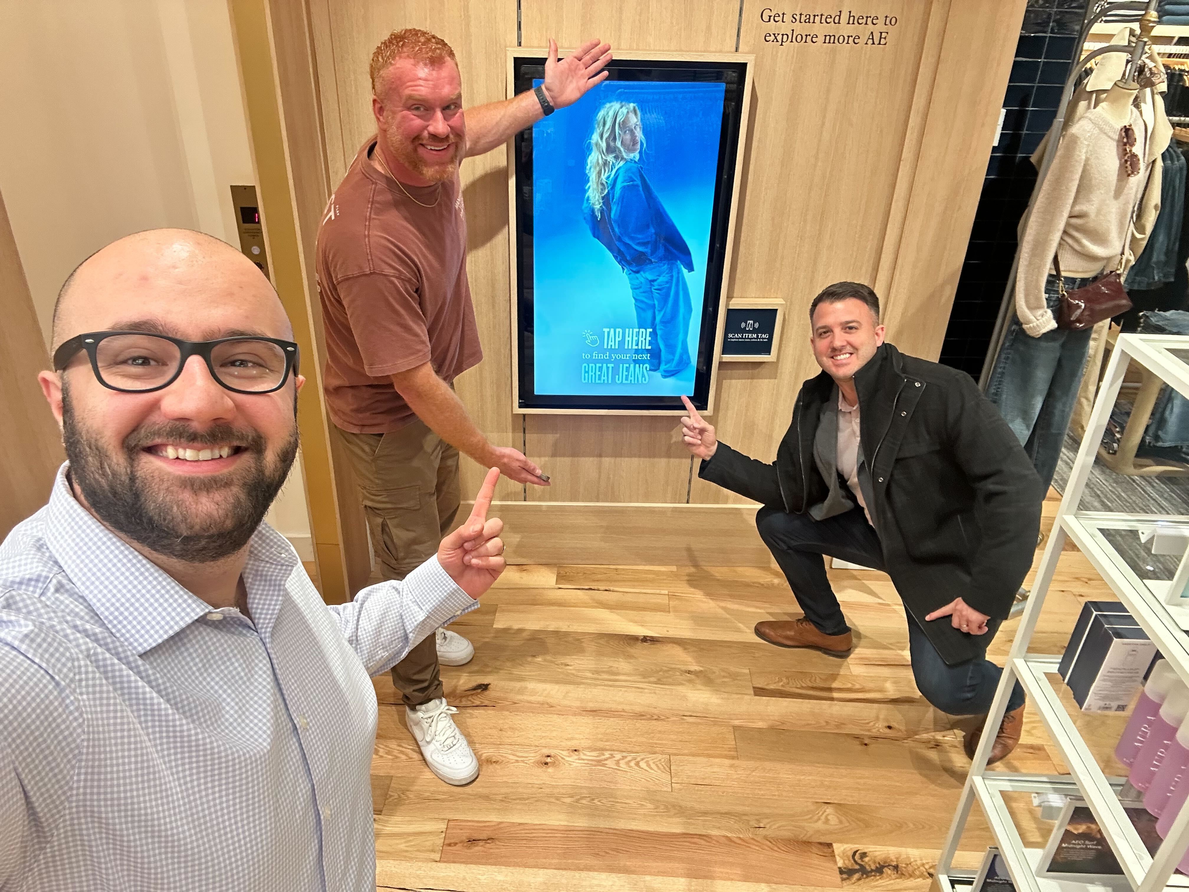 Members of the Crave team in an American Eagle store beside a live Crave touchpoint